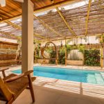 pool area with heart and swing covered by natural wood roof for shadow