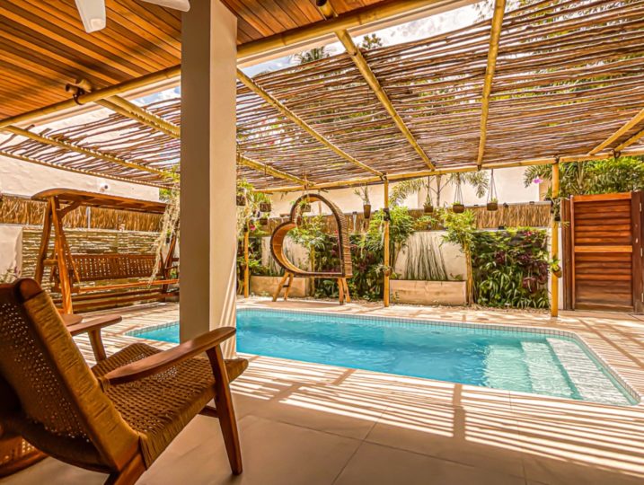 pool area with heart and swing covered by natural wood roof for shadow